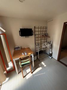 ein Wohnzimmer mit Tisch und Fernseher in der Unterkunft サンハウス六本松103 in Susakiuramachi