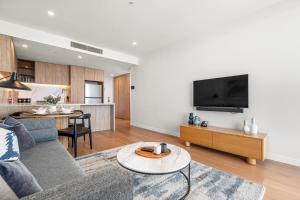 a living room with a couch and a tv at Casino & Luxury Sky High Oceanview 2BR 2BA Parking in Gold Coast