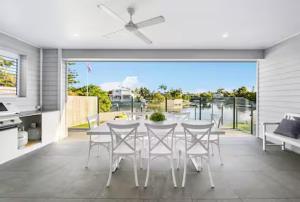 una sala da pranzo con tavolo e sedie di Capri Waterfront Resort-Style 5BR & Pool a Gold Coast