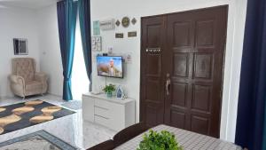 een woonkamer met een bruine deur en een stoel bij Mariamz Homestay near jetty Perhentian Island in Kampong Baru