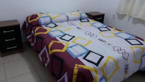 a bed with a colorful comforter in a room at Casas El Timón A in Chuí
