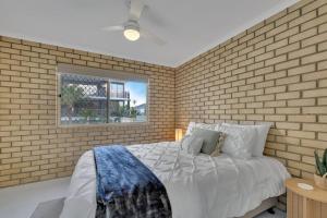 a bedroom with a brick wall and a bed at North Facing 2 Bedroom Apartment at Cotton Tree in Maroochydore