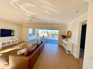 un ampio soggiorno con divano e TV di Capri Waterfront Resort-Style 5BR & Pool a Gold Coast