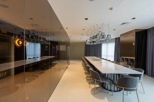a dining room with a long table and chairs at Novotel Rockwell View Hotel Residences in Manila +60 photos
