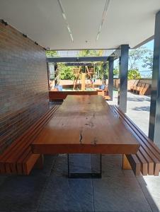a large wooden table in a room with a brick wall at Meu Apartamento a 15min de Copacabana in Rio de Janeiro
