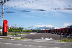 an empty parking lot with red and white dividers at HOTEL R9 The Yard Shibukawa in Akutsu +16 photos