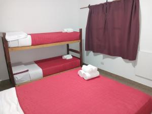 Camera con 2 letti a castello e tappeto rosso. di Los Jazmines depto a Cafayate