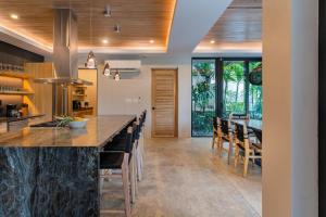 an open kitchen with a large counter and chairs at NEW Modern 6BR, Pool, Walk 2 Beach, Sleeps 20 in Playa Guiones