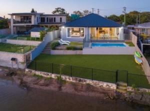 a house with a swimming pool in the yard at Capri Waterfront Resort-Style 5BR & Pool in Gold Coast