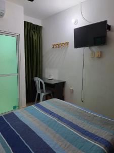 Un dormitorio con una cama, un escritorio y un televisor. en Arriendo habitaciones amobladas con aire acondicionado, en Montería