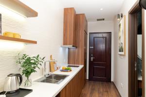 eine Küche mit einem Waschbecken und einer Holztür in der Unterkunft MYAN Villa Phòng nghỉ 5 có sân sau Vinhomes Ocean Park 3 in Ðình Loan