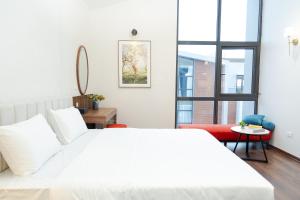 ein weißes Schlafzimmer mit einem weißen Bett und einem Fenster in der Unterkunft MYAN Villa Phòng nghỉ 5 có sân sau Vinhomes Ocean Park 3 in Ðình Loan