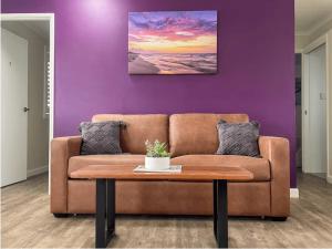a living room with a brown couch and a table at Quarterdeck Apartments in Gladstone