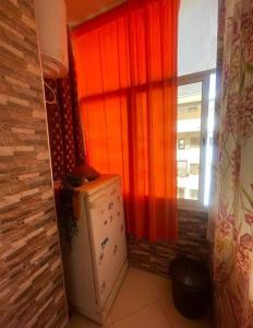 a kitchen with a refrigerator in front of a window at Appartement rénové Agadir in Agadir