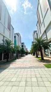 eine Stadtstraße mit Palmen und Gebäuden in der Unterkunft MYAN Villa Phòng nghỉ 5 có sân sau Vinhomes Ocean Park 3 in Ðình Loan