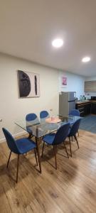 a dining room with a glass table and blue chairs at Suites Oriente in Osorno