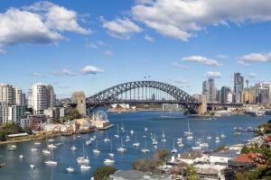 a view of a harbor with boats and a bridge at Breathtaking Sydney Harbour Views from Stylish Harbourside Studio in Sydney
