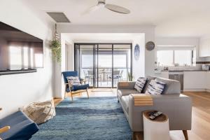 a living room with a couch and a kitchen at Beach Stayz Semaphore Upstairs Two Bedroom Apartment in Port Adelaide
