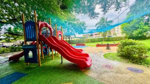 a playground with a red slide in a park at Terravive in Manila