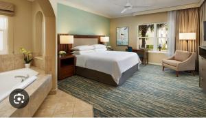 una habitación de hotel con una cama y una bañera en Sheraton Vistana resort, en Orlando