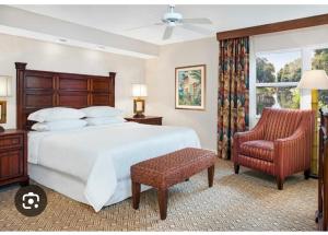 Un dormitorio con una cama grande y una silla. en Sheraton Vistana resort, en Orlando
