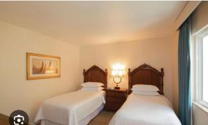 Un dormitorio con dos camas y una ventana. en Sheraton Vistana resort, en Orlando