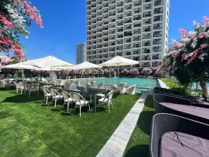 Un patio con mesas y sillas y una piscina. en Apartment Seaview, en Nha Trang