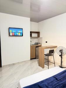 a bedroom with a bed and a desk and a kitchen at Coliving C33- Apartaestudios En Palmira Centro in Palmira