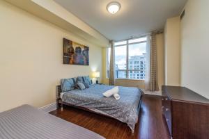 Un dormitorio con una cama y una ventana grande. en Ideal 2BR & 2 BTH - Near SQ1 Mall, en Mississauga 103 fotos más