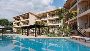 a hotel with a swimming pool in front of a building at Brand New Condo near beach in Santa Cruz Huatulco