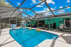 una piscina cubierta en una casa con techo de cristal en 111 Sunset Drive, en Cocoa Beach