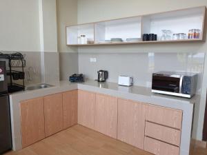 a kitchen with a counter with a sink and a microwave at Freddies Villas Sabang in Sabang
