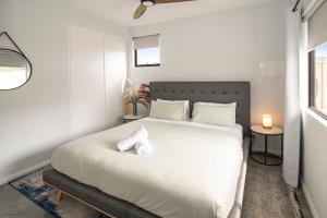 バッセルトンにあるBayside Luxury Escape Busselton with EV chargerの大きな白いベッドと2つのランプのある寝室