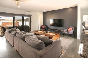 バッセルトンにあるBayside Luxury Escape Busselton with EV chargerのソファと薄型テレビのあるリビングルーム