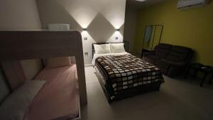 a bedroom with a bed and a couch and a chair at Habitación Chero Platinum in Comalcalco