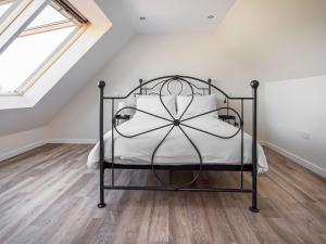 a bedroom with a black bed in a attic at Y Bwthyn in Culbokie