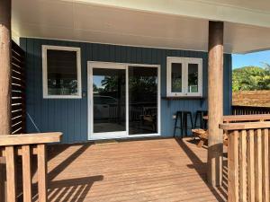 a porch of a house with a wooden deck at Sharnyta's Studio Aitutaki in Amuri