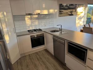 フレーザー島にある719 Cooloola Villa at Kingfisher Bay K'gari Fraser Islandのシンクとカウンタートップのあるキッチン