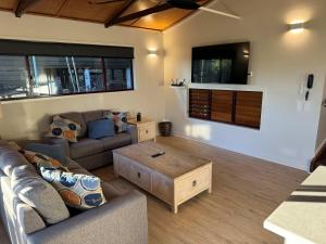 フレーザー島にある719 Cooloola Villa at Kingfisher Bay K'gari Fraser Islandのソファとコーヒーテーブルのあるリビングルーム