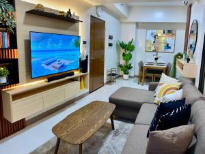 a living room with a large flat screen tv at Newtown's Best Suites in Punta Engaño
