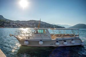 a boat is docked in the water on a lake at Palmon Bay Hotel & Spa in Herceg-Novi