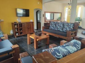 un salon avec des canapés et une télévision à écran plat dans l'établissement Villa's Serena, à Bertioga