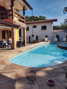 une piscine devant une maison dans l'établissement Villa's Serena, à Bertioga