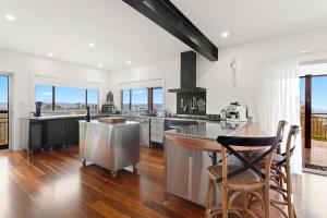 a kitchen with white walls and a wooden floor at The View @ Ulandi in Lowther