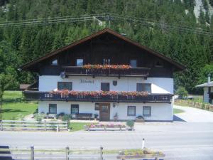 un edificio con flores encima en Ferienwohnung Fischerhof, en Leutasch