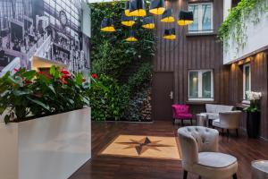 a lobby with chairs and plants in a building at Hotel Aida Marais in Paris