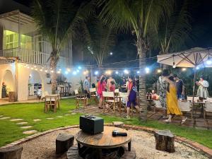 a group of people standing in a garden at night at Chon's Dock Homestay & House Lease in Phan Thiet