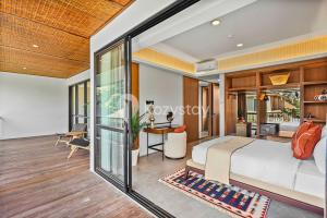 une chambre avec un grand lit et un bureau dans l'établissement Andra Villa by Kozystay - Natadesa Resort Jimbaran, à Jimbaran