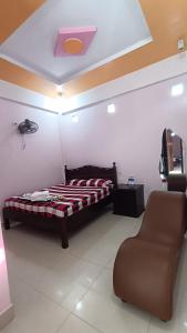 a bedroom with a bed and a chair in it at Khách Sạn Hoàn Mỹ in Thôn Nhan Biều (1)