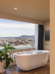 a bath tub in a room with a window at New Life Hotel - Da Lat in Da Lat